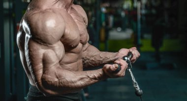 Yakışıklı model genç adam eğitim kollarında spor salonu