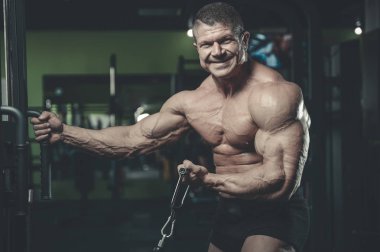 Yakışıklı model genç adam eğitim kollarında spor salonu