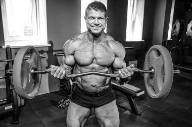 Yakışıklı model genç adam eğitim kollarında spor salonu