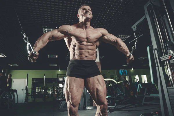 Brutal Caucasian bodybuilder training chest in gym — Stock Photo, Image