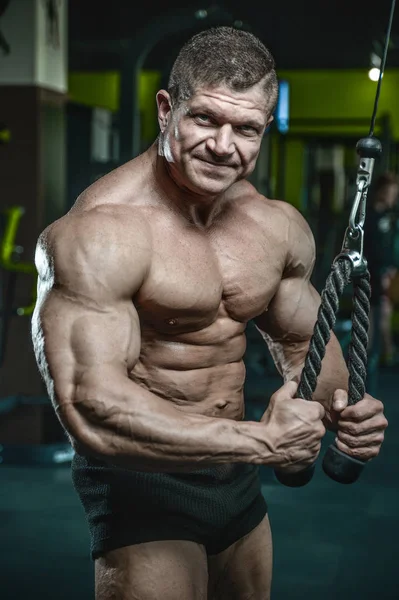 Yakışıklı model genç adam eğitim kollarında spor salonu