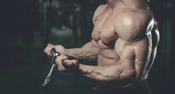 Bello modello giovane uomo formazione braccia in palestra — Foto Stock