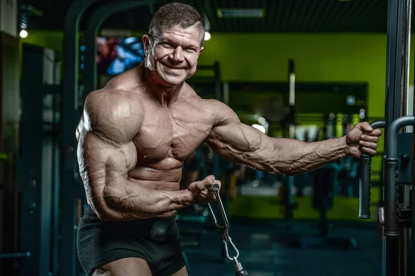 Handsome model young man training arms in gym