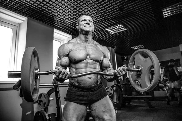 Yakışıklı model genç adam eğitim kollarında spor salonu