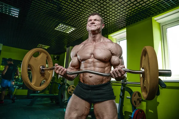 Handsome model young man training arms in gym