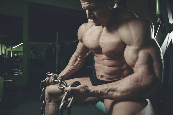 Brutal culturista haciendo ejercicio en el gimnasio con chai — Foto de Stock