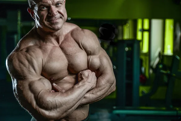 Brutal Caucasian bodybuilder working out in gym Stock Photo