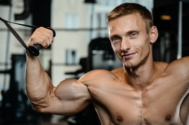 Yakışıklı model genç adam eğitim kollarında spor salonu