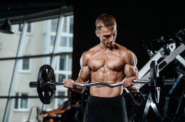 Yakışıklı model genç adam eğitim kollarında spor salonu