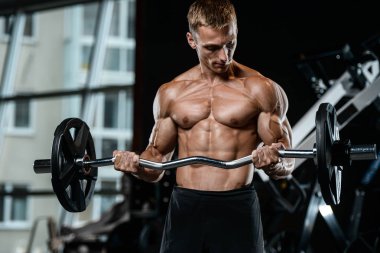 Yakışıklı model genç adam spor salonunda egzersiz