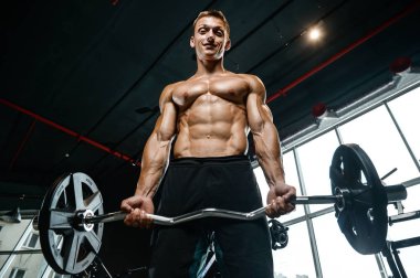 Yakışıklı model genç adam spor salonunda egzersiz