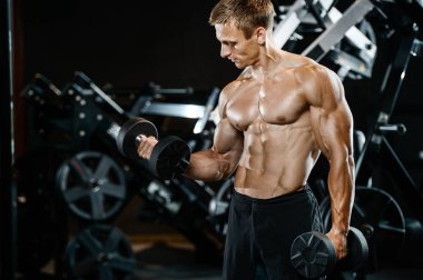 Yakışıklı model genç adam spor salonunda egzersiz