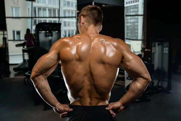 Knap model jongeman training terug in de sportschool — Stockfoto