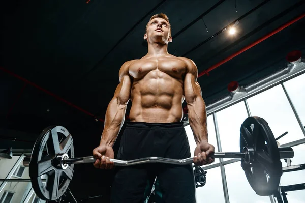 Yakışıklı model genç adam spor salonunda egzersiz