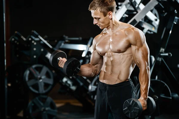 Yakışıklı model genç adam spor salonunda egzersiz