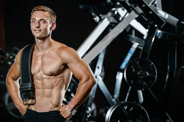Yakışıklı model genç adam spor salonunda egzersiz