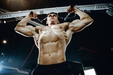 Yakışıklı model genç adam eğitim kollarında spor salonu