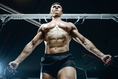 Yakışıklı model genç adam spor salonunda egzersiz