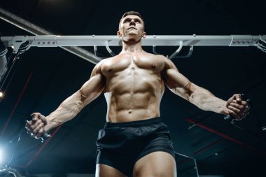 Yakışıklı model genç adam spor salonunda egzersiz