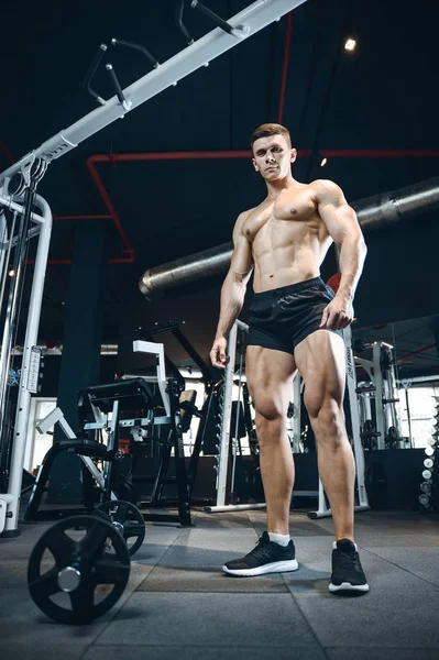 Yakışıklı model genç adam eğitim bacaklar içinde jimnastik salonu — Stok fotoğraf