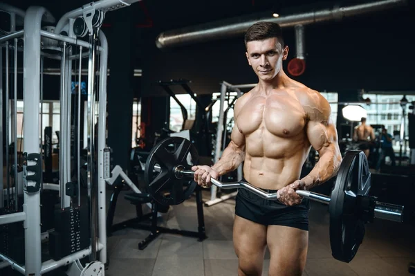 Yakışıklı model genç adam spor salonunda egzersiz — Stok fotoğraf