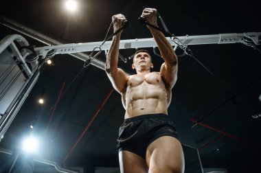 Yakışıklı model genç adam spor salonunda egzersiz