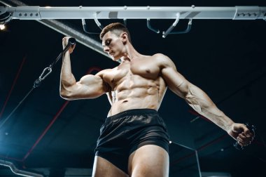 Yakışıklı model genç adam eğitim kollarında spor salonu