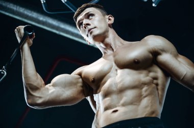 Yakışıklı model genç adam eğitim kollarında spor salonu