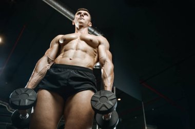 Yakışıklı model genç adam spor salonunda egzersiz