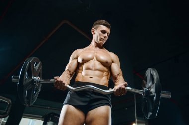 Yakışıklı model genç adam eğitim kollarında spor salonu