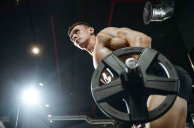 Yakışıklı model genç adam eğitim kollarında spor salonu