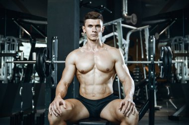Yakışıklı model genç adam spor salonunda egzersiz