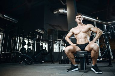 Yakışıklı model genç adam spor salonunda egzersiz