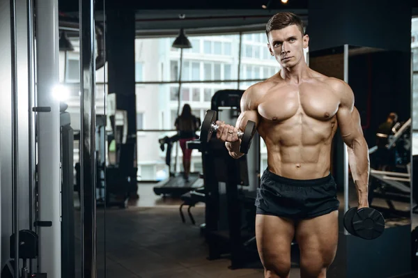 Beau modèle jeune homme travaillant dans la salle de gym — Photo