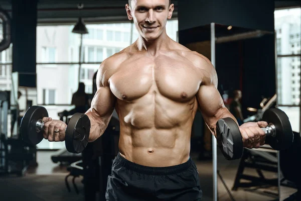 Gut aussehend modell junger mann training arms im fitnessstudio — Stockfoto