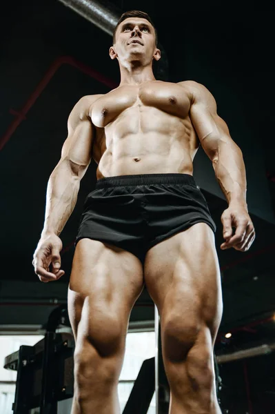 Handsome model young man training legs in gym — Stock Photo, Image