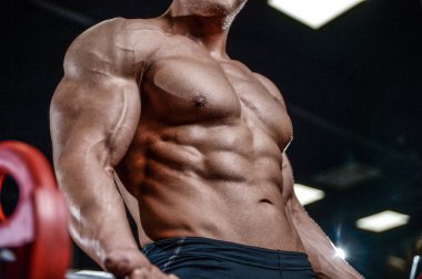 Yakışıklı model genç adam eğitim kollarında spor salonu