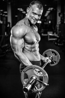 Yakışıklı model genç adam eğitim kollarında spor salonu