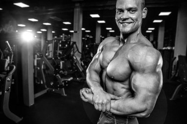 Yakışıklı model genç adam eğitim kollarında spor salonu