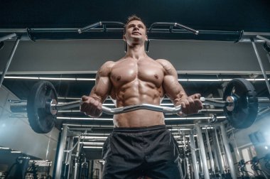 Yakışıklı model genç adam eğitim kollarında spor salonu