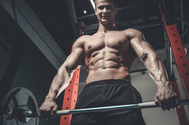Yakışıklı model genç adam eğitim abs spor salonunda