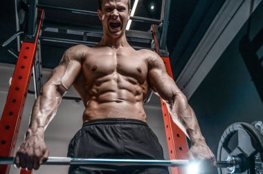 Yakışıklı model genç adam eğitim abs spor salonunda