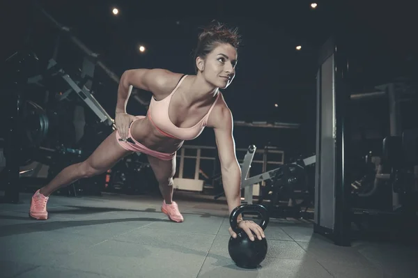 Сексуальная спортивная девушка тренирует руки в спортзале — стоковое фото