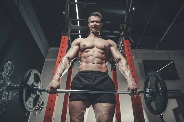 Guapo modelo joven hombre entrenamiento abs en gimnasio —  Fotos de Stock