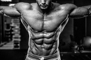 Yakışıklı model genç adam eğitim abs spor salonunda