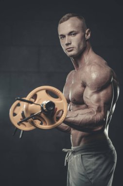 Yakışıklı model genç adam eğitim kollarında spor salonu
