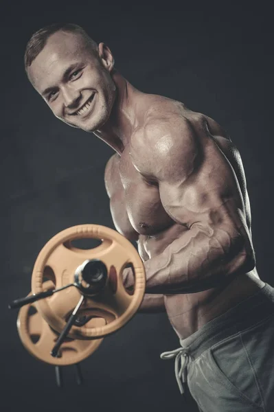 Handsome model young man training arms in gym