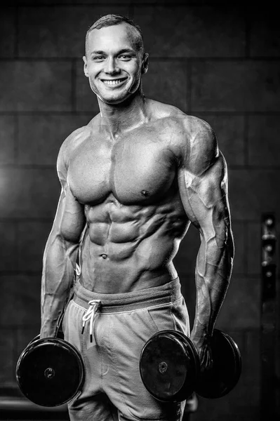 Guapo modelo joven hombre entrenamiento abs en gimnasio —  Fotos de Stock