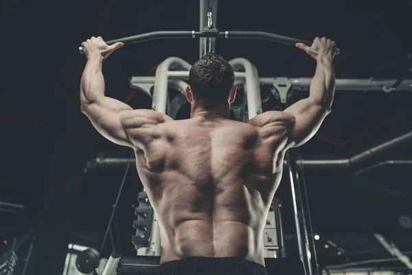 Handsome model young man training back in gym