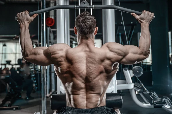 Handsome model young man training back in gym